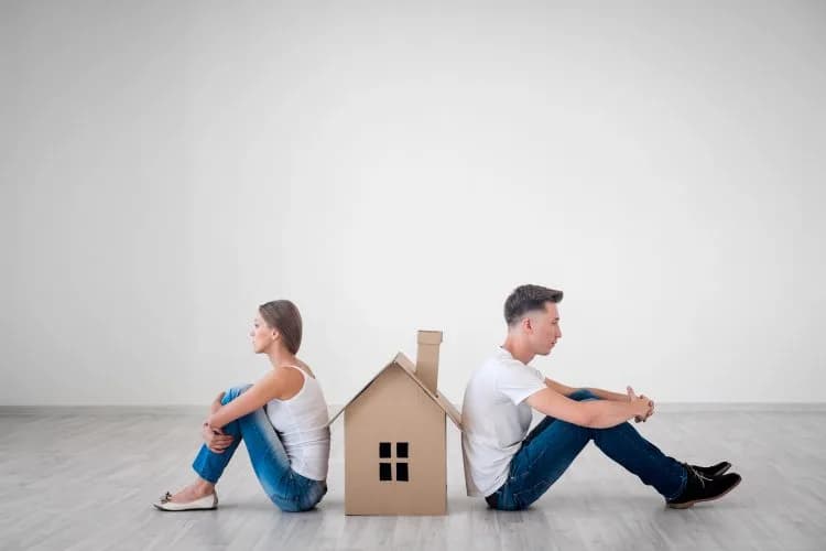 A couple signing a contract to sell their house during a divorce